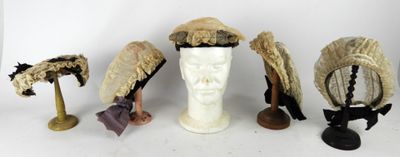 cinq chapeaux posés sur la tête d'un mannequin