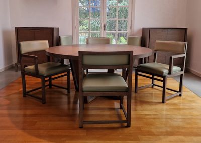 a wooden table with four chairs around it in a room