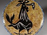 une photo d'une assiette décorative sur laquelle figure un coq