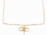 a gold chain necklace with a knot and a cross on it