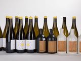 plusieurs bouteilles de vin sont alignées sur une surface blanche
