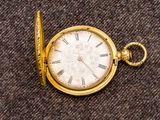 une montre de poche en or avec des chiffres romains