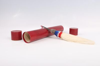 a red tube with a toothbrush and a tooth brush on it