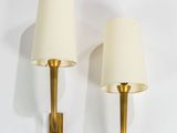 pair of brass sconces with white lamps on a white background