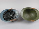 two green and blue bowls sitting next to each other on a white surface