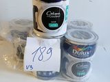 deux pots de peinture Duluxx et une tasse de café posés sur une table