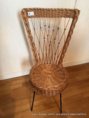 a wicker chair that is sitting on a wooden floor