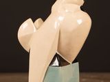 a ceramic sculpture of a bird sitting on top of a box