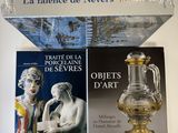 two books and a glass vase on a table