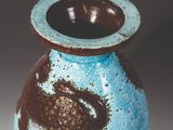 a blue and brown vase sitting on a table