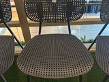 three chairs that are sitting on the grass by the window