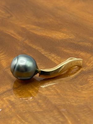 une perle noire posée sur une table en bois, à côté d'une banane
