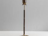 a brass floor lamp with a wooden base and a metal shade