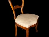 a wooden chair with a white seat and a black background