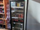a refrigerator in a store with a sign on the door