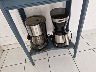 deux cafetières posées sur une petite table bleue
