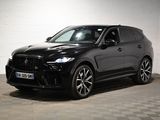 Le SUV noir est garé dans une grande pièce au sol carrelé en damier.