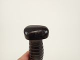 someone is holding a black screw in their hand against a white background
