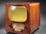 an old fashioned television sitting on top of a wooden stand