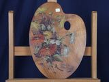 un chevalet en bois sur lequel est peinte une composition florale