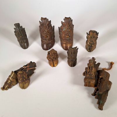 plusieurs pièces de bois sculpté sont disposées sur une surface blanche