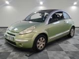 a small green car parked in a room with checkered floor