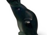 a black cat statue sitting on a white surface