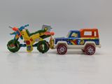 a toy truck and a toy motorcycle on a white surface