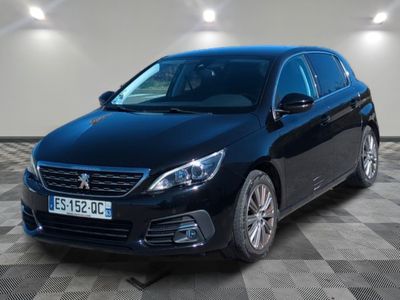 la voiture noire est garée sur un sol en damier dans le garage
