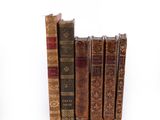 plusieurs vieux livres sont empilés sur une surface blanche