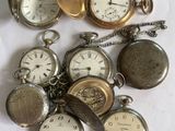 many different types of pocket watches sitting on a table