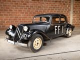 a black car parked in a garage next to a brick wall