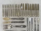 a lot of silverware on a table with knives and spoons