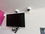 a flat screen tv mounted on the wall next to two security cameras