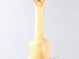 a guitar hanging from a string on a white wall