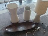 une table sur laquelle se trouvent une lampe, des vases et une assiette