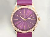 the purple watch has a diamond bezeled face and a pink leather strap