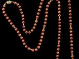 un collier de perles rouges sur fond noir