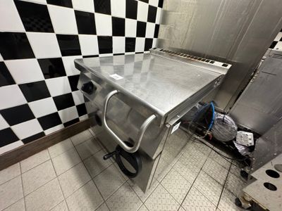 a stainless steel table in a kitchen with a checkered wall behind it