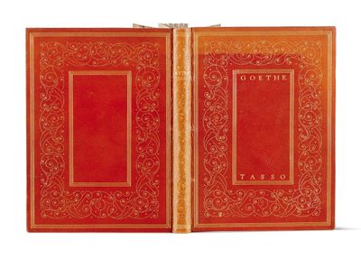 an old book with a red cover and gold trim