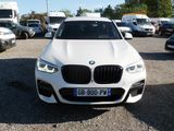 a white bmw suv parked in a lot with other cars