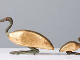 two bronze birds that are sitting on a table