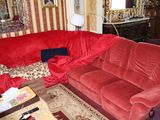 un canapé rouge dans un salon avec un miroir accroché au mur