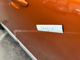 an orange car with a sticker on the side of it ' s door