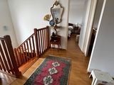 a hallway with a rug on the floor and a lamp hanging from the ceiling