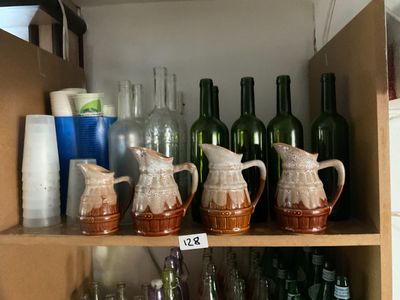 de nombreuses bouteilles et vases posés sur une étagère dans un meuble