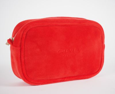 une trousse de toilette rouge posée sur une surface blanche