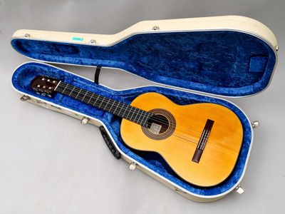 une photo d'une guitare dans son étui, posée sur une table