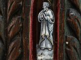a statue of a man holding a cross in a wooden frame