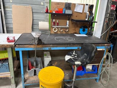 un établi sur lequel se trouve un seau jaune, dans un garage